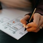 a person doing ux work on a paper for a multiplatform app